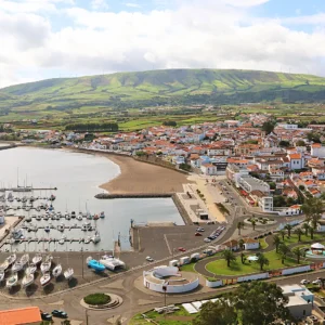 Aerial view of Terceira Island harbor with boats, marina, and surrounding landscape.