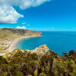 Panoramic view of the coastline and ocean surrounding Santa Maria Island under a blue sky.