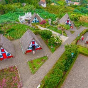 Aerial view of traditional thatched roof houses in Santana, surrounded by gardens and pathways.