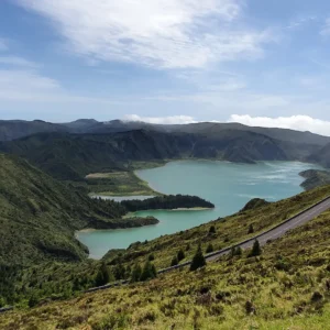 A panoramic view of the Sete Cidades lakes surrounded by green hills and mountains.
