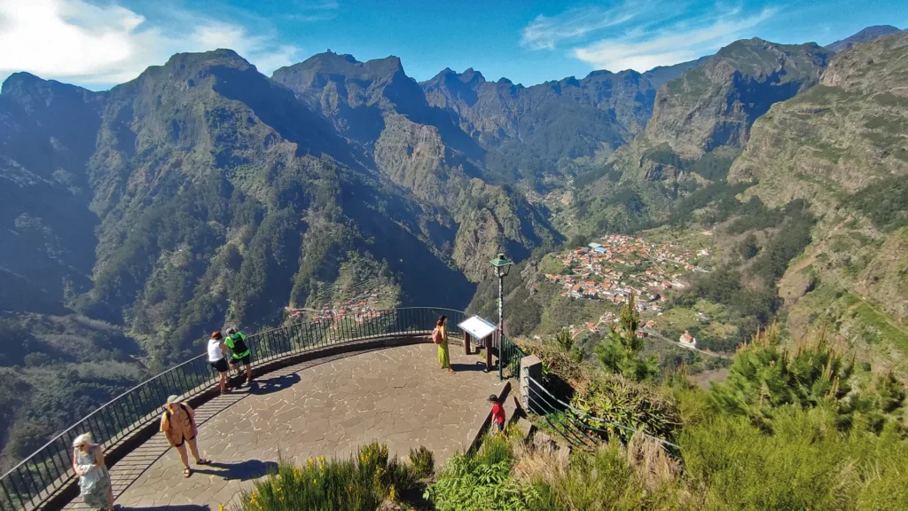 Scenic viewpoint overlooking Nuns Valley with mountains and a village in the distance.